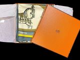 an orange box containing a scarf with a picture of a horse on it