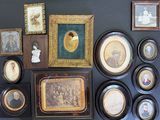 many framed pictures on the wall of this room