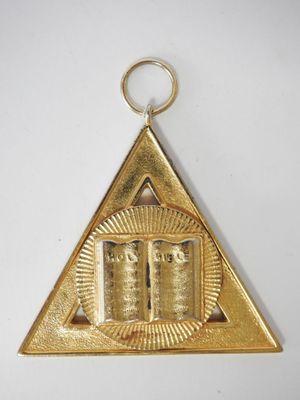 une image représentant un triangle plaqué or sur lequel repose un livre