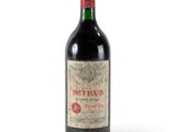 une bouteille de vin rouge posée sur une table blanche