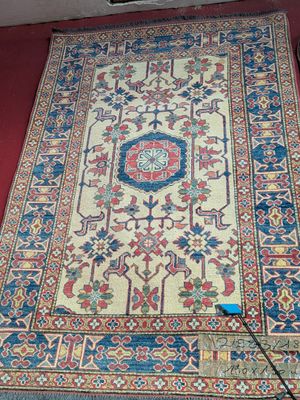 an image of a rug on the floor with a red wall behind it