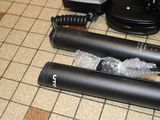 two microphones on a tiled floor next to a coffee maker
