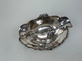 a silver plate with a bird on it on a table