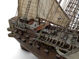 a wooden model of a sail boat on a stand