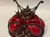 a red vase with a crown on top of it