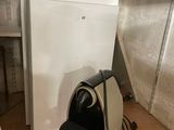 a white refrigerator and a black trash can in a room