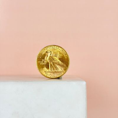 a gold coin sitting on top of a marble block