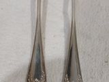 deux cuillères en argent et une fourchette posées sur une serviette blanche
