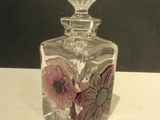 une bouteille en verre transparent ornée d'un motif floral