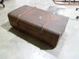 une valise marron posée sur le sol d'une pièce