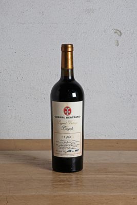 une bouteille de vin rouge posée sur une table en bois