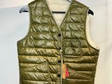 Le gilet est vert et porte une étiquette rouge.