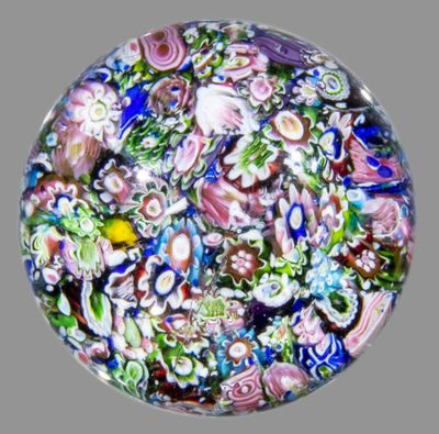 une photo d'un presse-papier en verre orné de nombreuses fleurs