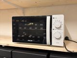 un micro-ondes posé sur une étagère dans un magasin
