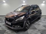la voiture noire est garée sur un sol en damier dans le garage