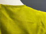 a close up of a green shirt with a white button on it