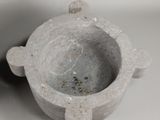 a small white vase with a flower design on it