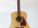 an acoustic guitar sitting on top of a stand against a white wall