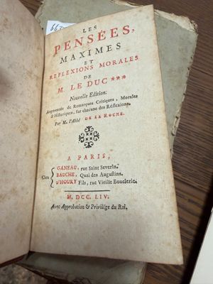 un vieux livre posé sur une table recouverte de papiers
