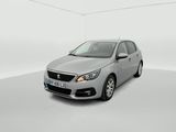 La voiture argentée est garée dans une pièce blanche au sol blanc.