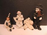 five figurines of clowns sitting on a table