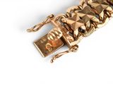 a close up of a gold bracelet on a white surface