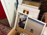 une boîte en carton remplie de photos et d'autres objets, posée par terre