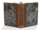 un vieux livre à la couverture brune posé sur une table