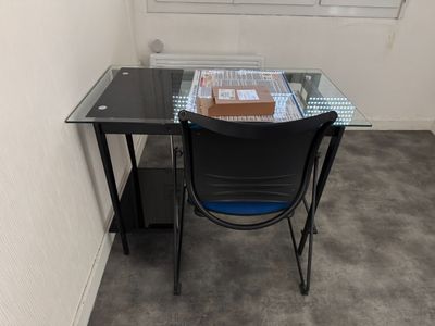 une table en verre sur laquelle est posé un livre, dans une pièce