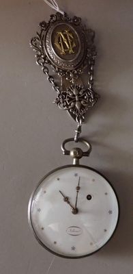 a clock hanging on the wall with a chain attached to it