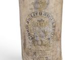 an old bottle of wine is sitting on a white surface