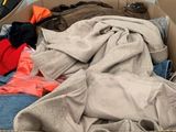 a cardboard box filled with clothes and a pair of shoes