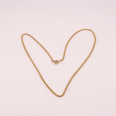 un collier en or avec un pendentif en forme de cœur sur fond blanc