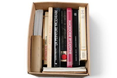 une boîte de livres sur fond blanc, avec un stylo
