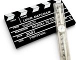 a watch sitting next to a clap board on a white surface