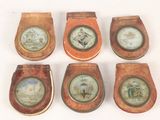 six wooden toilet seats with pictures on them on a white surface