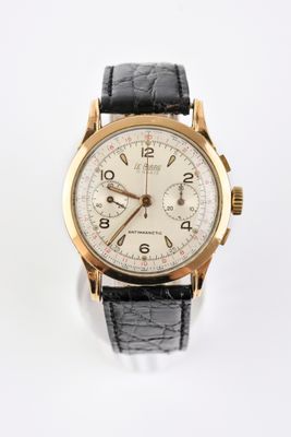 un gros plan d'une montre sur une surface blanche avec un fond blanc