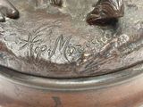 une statue en bronze représentant un chien et un chat posée sur une table