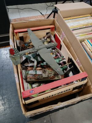 une boîte remplie de livres et un avion miniature