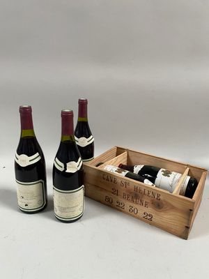 trois bouteilles de vin dans une caisse en bois sur fond blanc