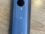 a blue camera sitting on a table next to a pair of scissors