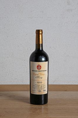 a bottle of red wine sitting on a wooden table