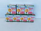 four boxes of bright yellow light bulbs sitting on a white surface