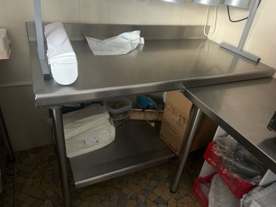 a stainless steel work table with a towel on top of it