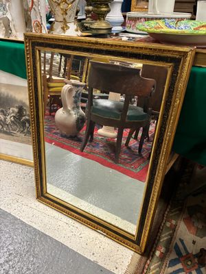 un miroir posé par terre à côté d'une table