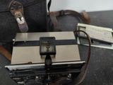 a camera sitting on a table next to a bag