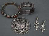 deux bijoux en argent posés sur une table