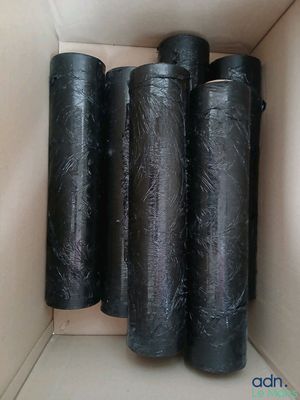 quatre rouleaux de plastique noir emballés dans une boîte