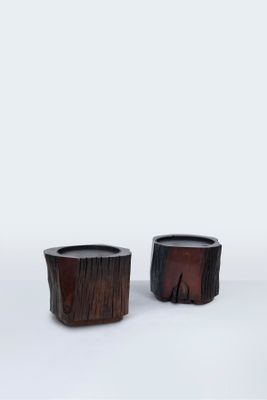 une paire de petites jardinières en bois posées sur une surface blanche