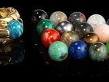 plusieurs billes de différentes couleurs et des anneaux dorés sur un fond noir